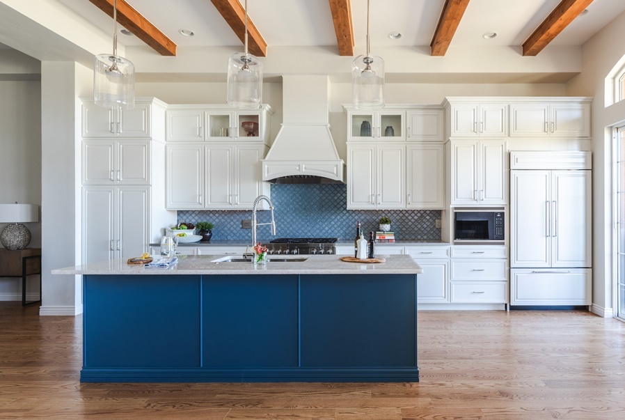 White shaker kitchen with navy island and exposed wood beam ceiling
