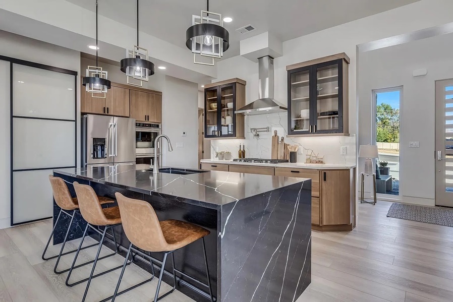 Modern kitchen with black marble waterfall island and mixed cabinet finishes