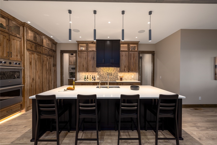 Large open kitchen with knotty alder cabinets and navy upper accent